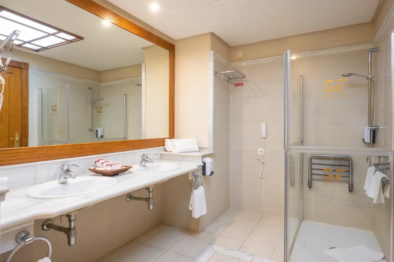 un baño de hotel con dos lavabos y una ducha