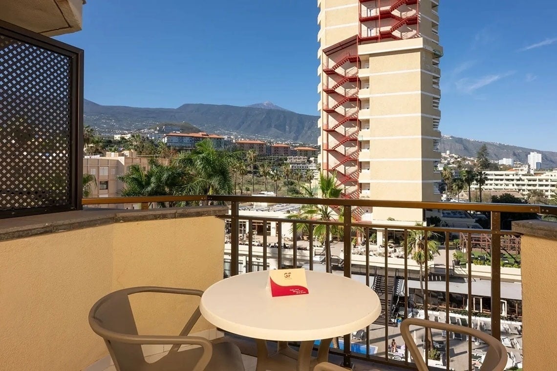 un balcón con una mesa y sillas y una tarjeta que dice ' tenerife ' en ella