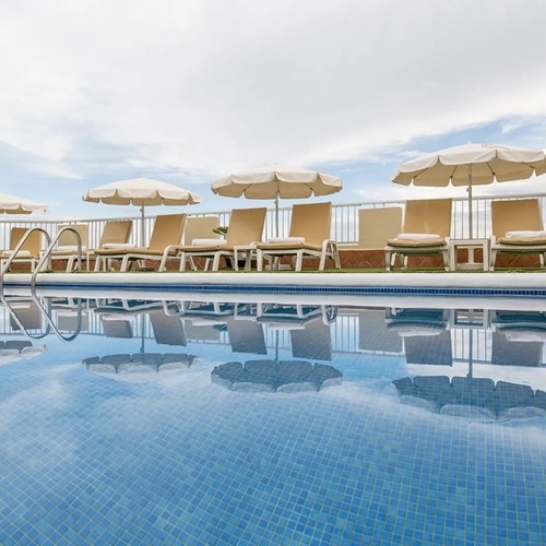 una piscina con sillas y sombrillas alrededor de ella