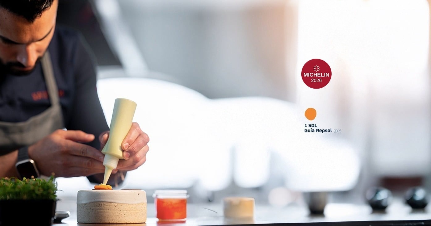 una mesa en un restaurante con un cartel rojo que dice michelin 2025