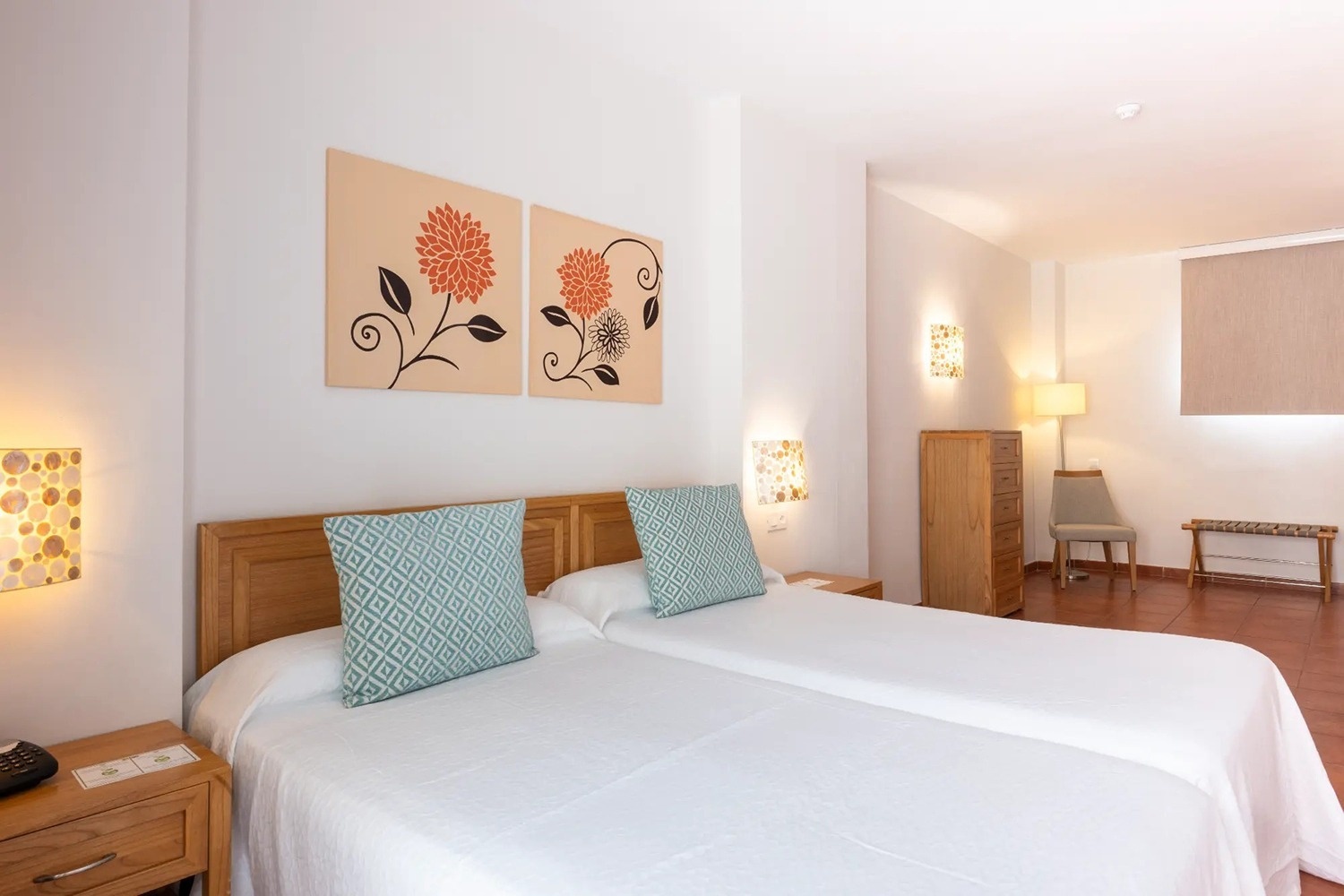 una habitación con dos camas y dos cuadros en la pared