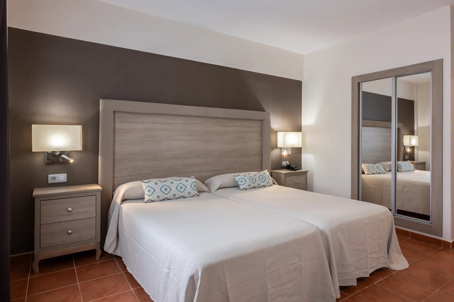 un dormitorio con dos camas y un espejo