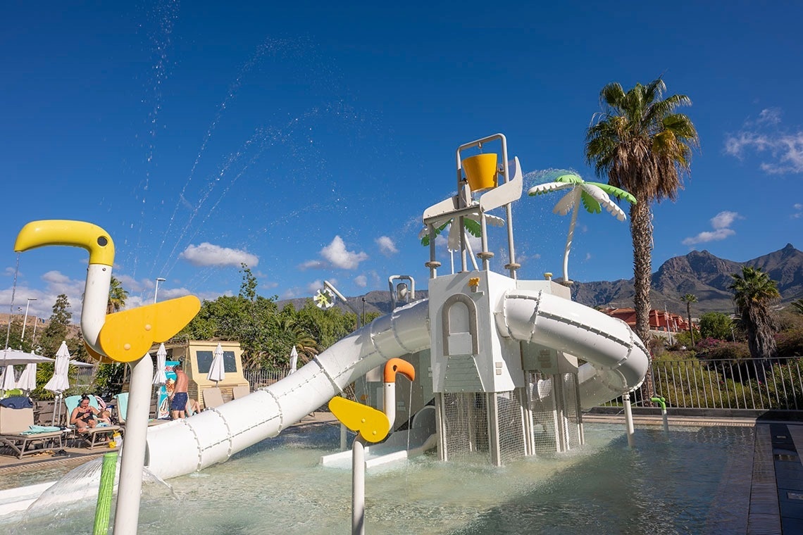 un parque acuático para niños con toboganes y palmeras