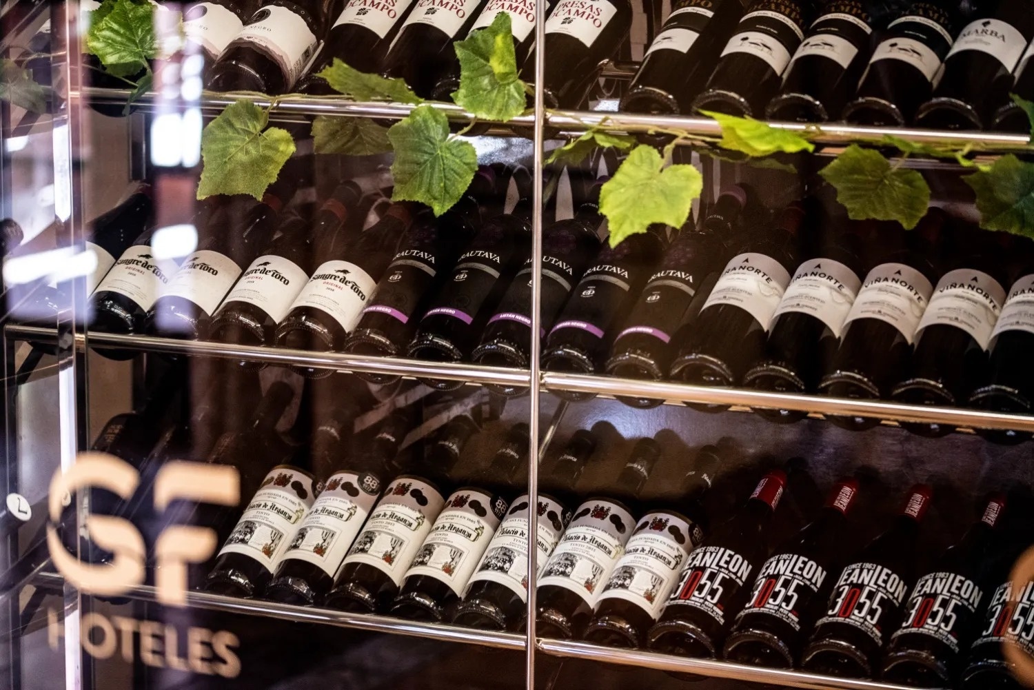 un estante lleno de botellas de vino con la palabra hoteles al fondo