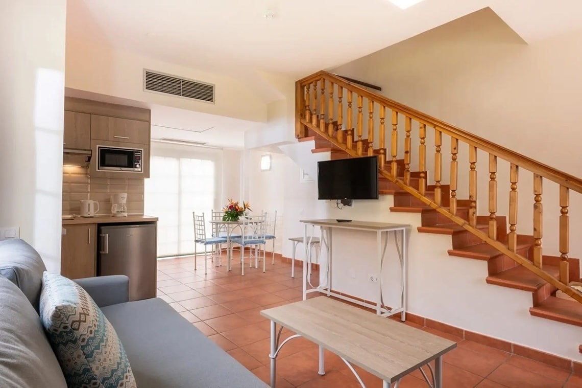 una sala de estar con escaleras y una televisión