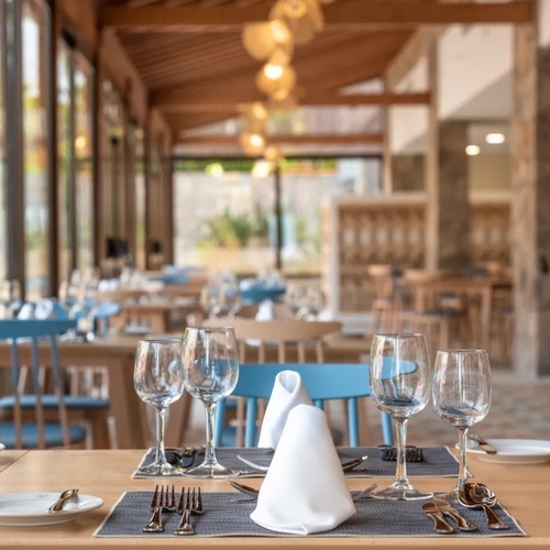 un restaurante con mesas y sillas azules y copas de vino