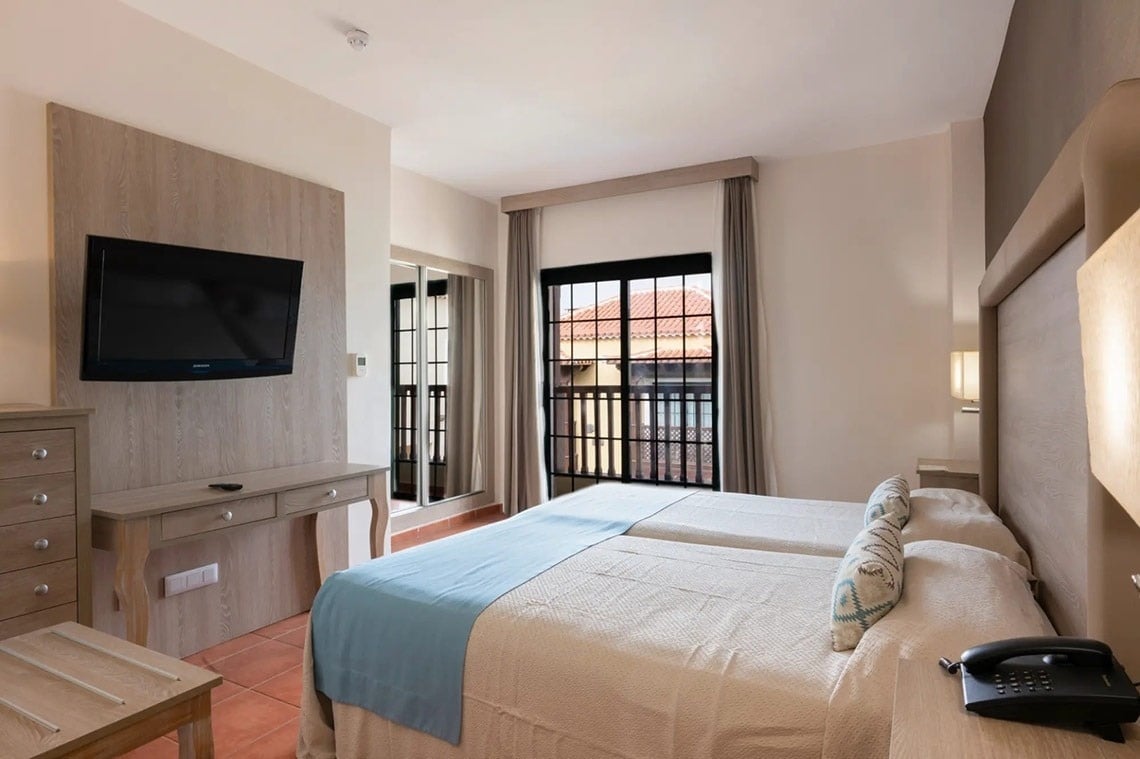 una habitación de hotel con dos camas y una televisión