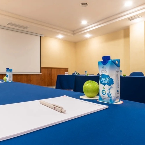 una sala de conferencias con una manzana y una caja de agua