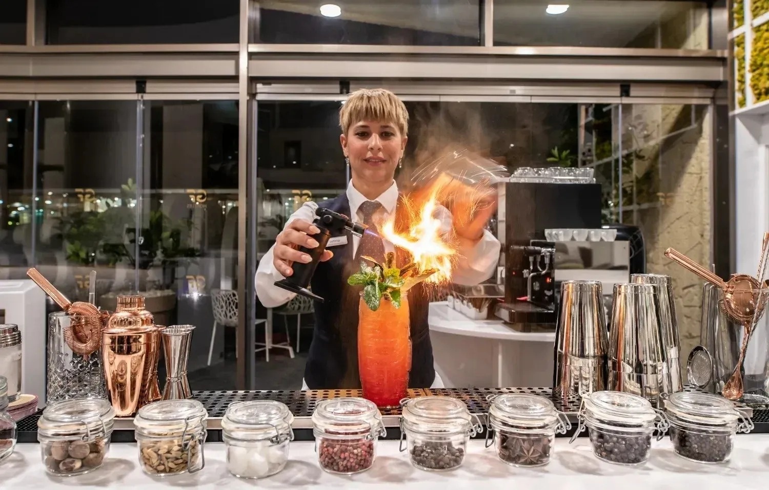 una mujer está preparando un cóctel en un restaurante
