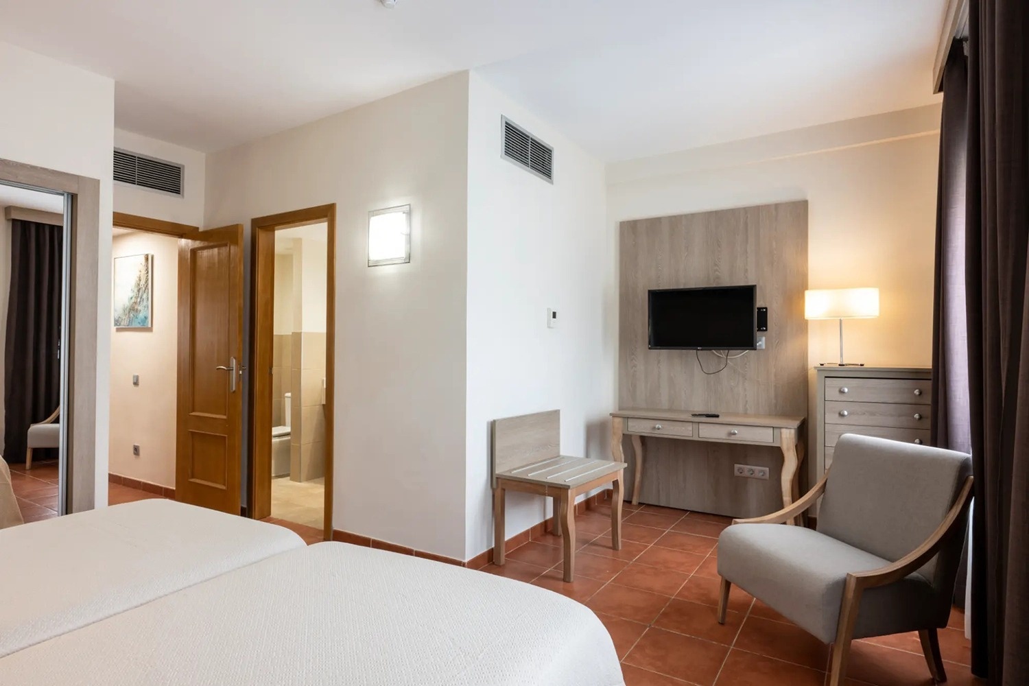 una habitación de hotel con una cama y una televisión