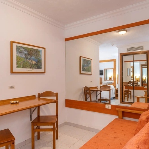 una habitación con un sofá y una mesa y sillas