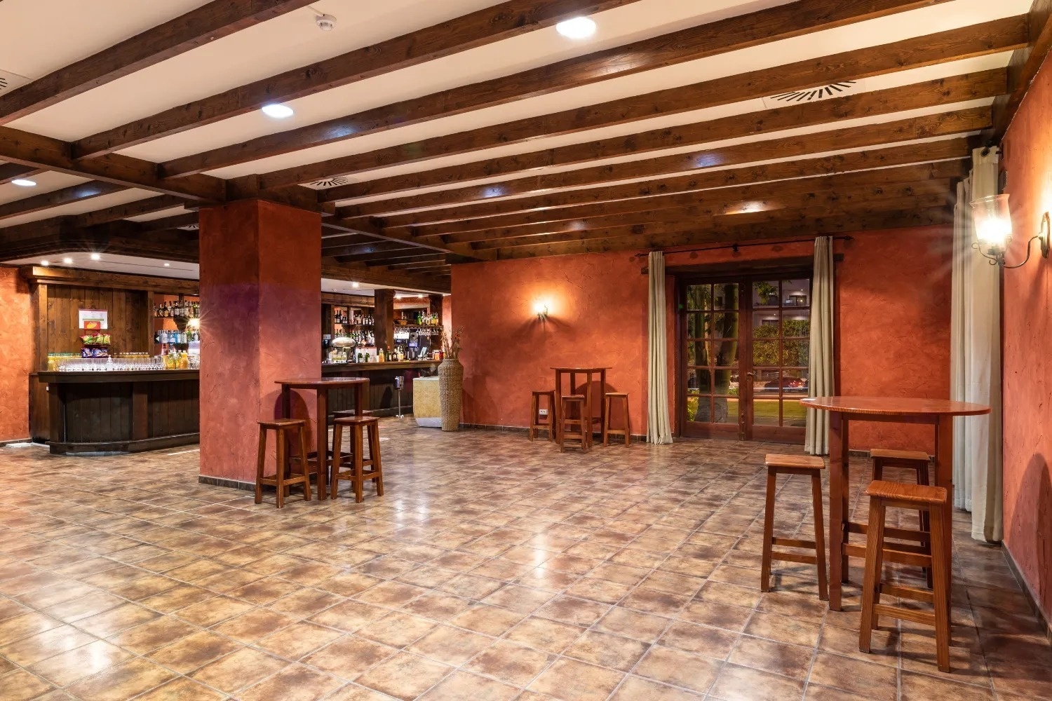 una mesa con copas de vino y un espejo con la palabra ajaj en la pared