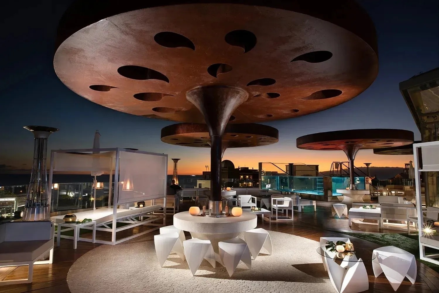 una habitación con una mesa y sillas y una piscina al fondo