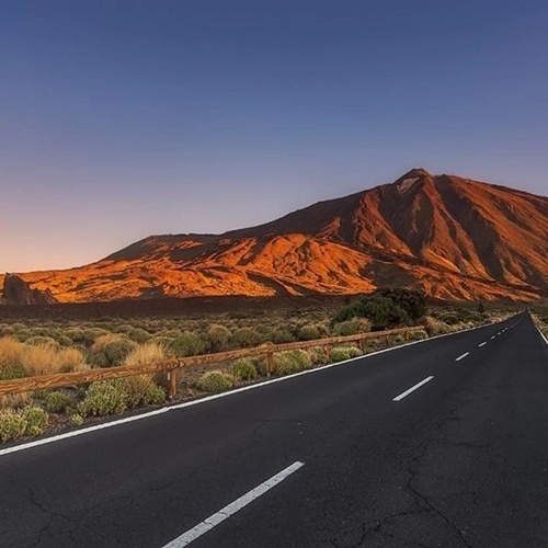 una carretera con una montaña en el fondo