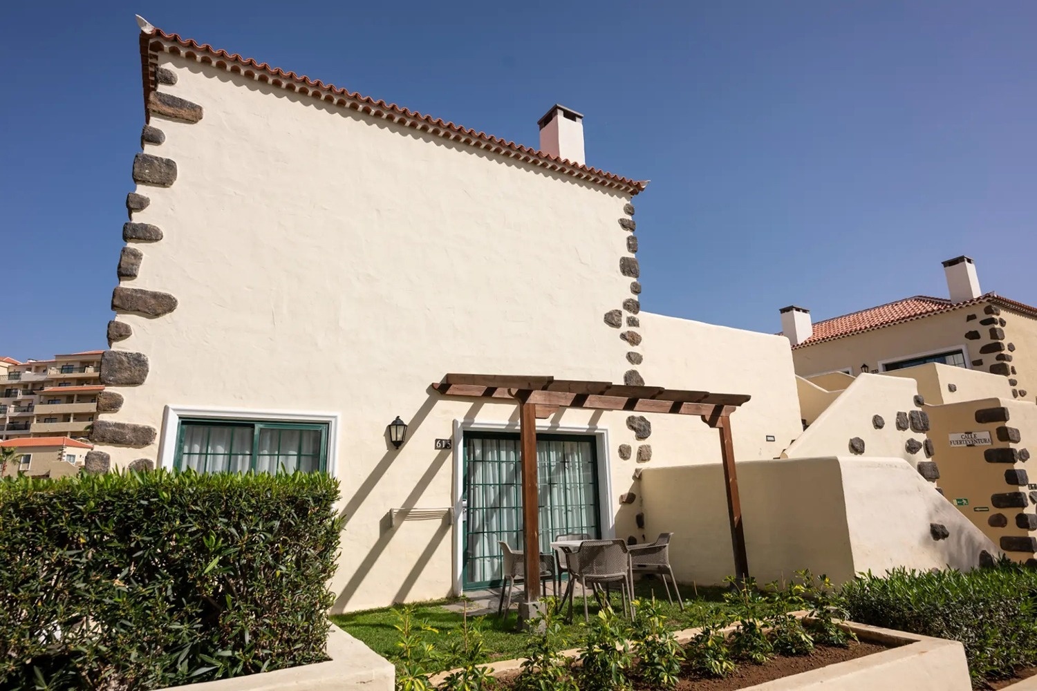 una pequeña casa con una mesa y sillas en el patio