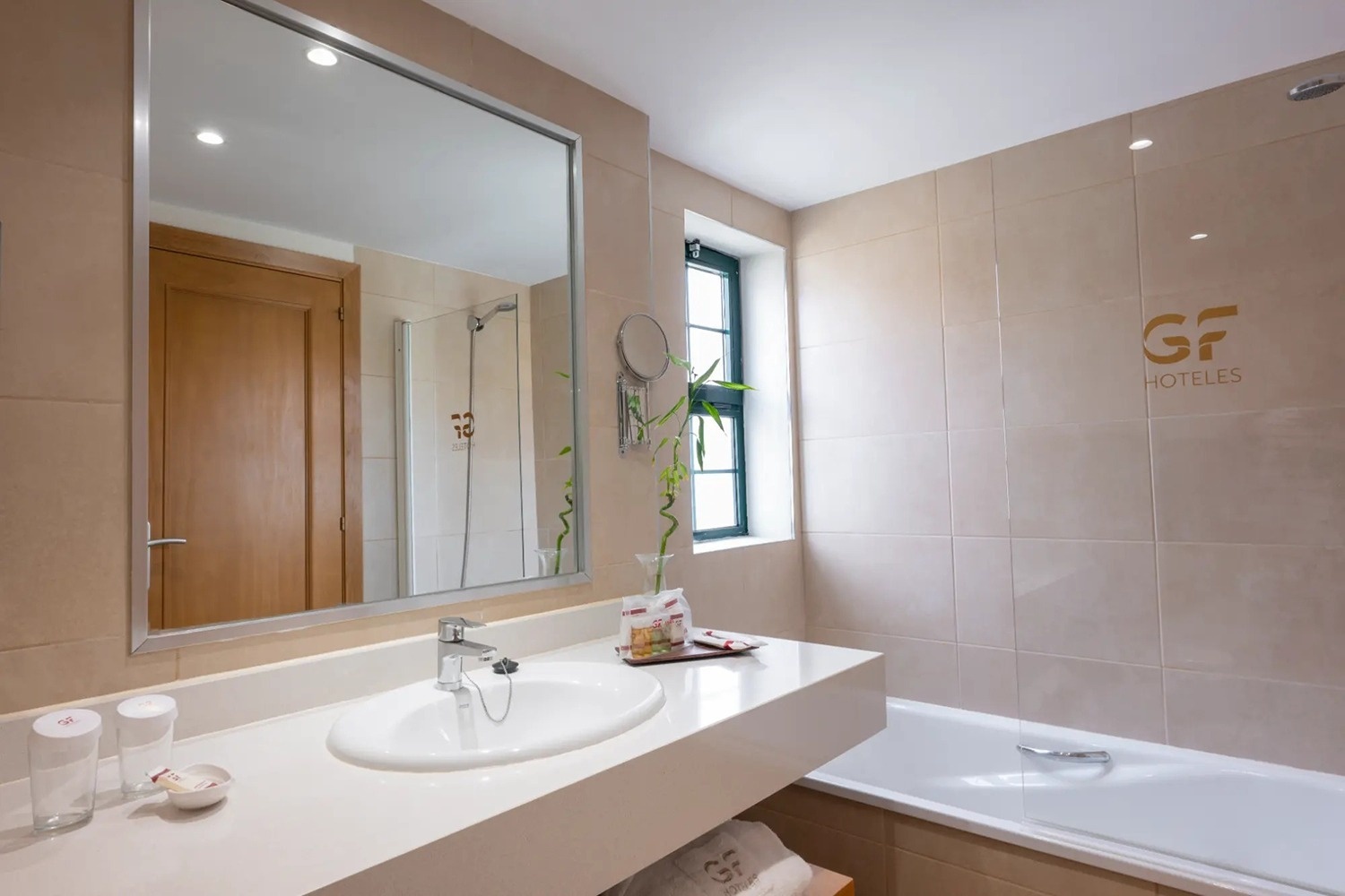 un baño con un lavabo y una bañera y la palabra hoteles en la pared