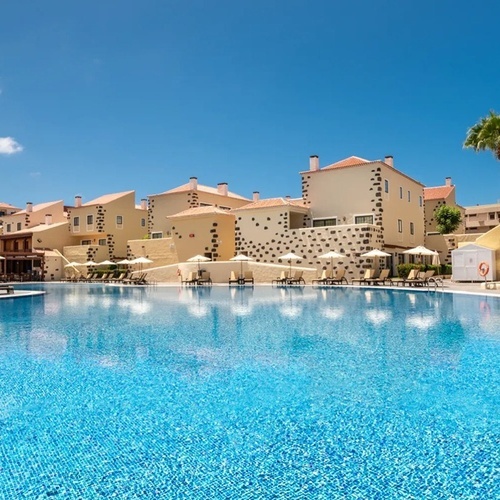 a large swimming pool surrounded by chairs and umbrellas