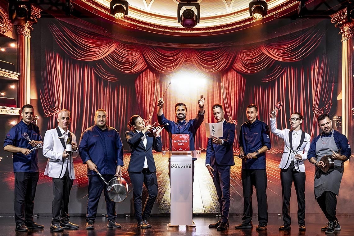 un grupo de chefs y camareros posan para una foto en un escenario