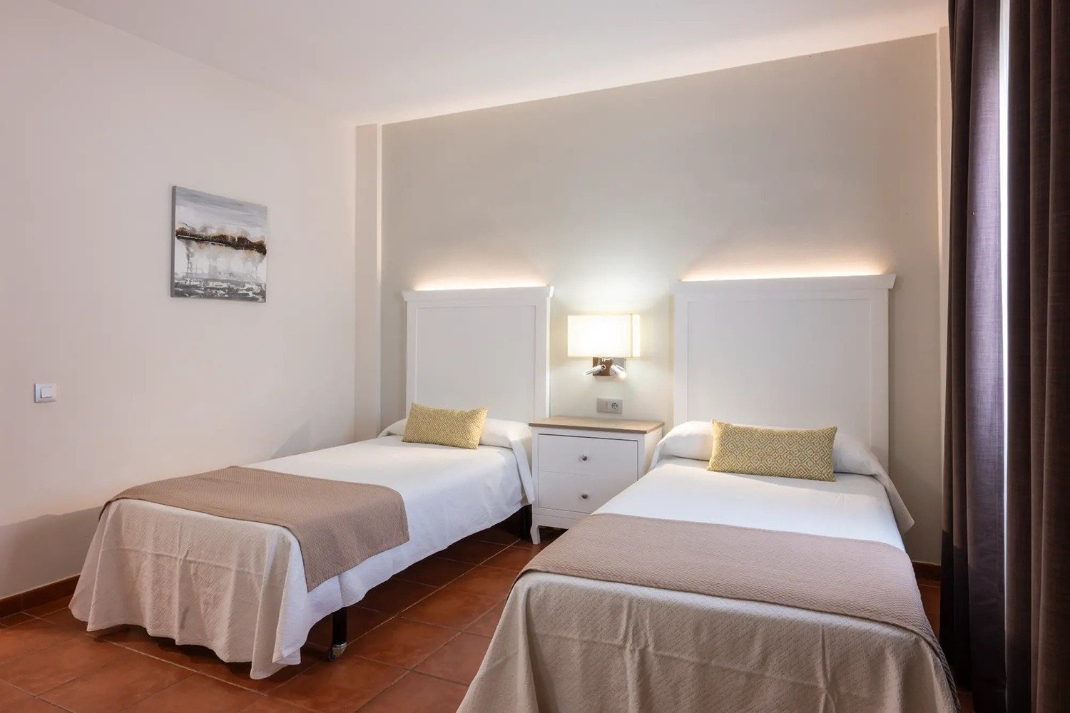 una habitación con dos camas y una pintura en la pared