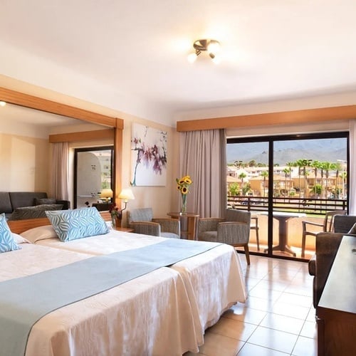 a hotel room with two beds and a balcony