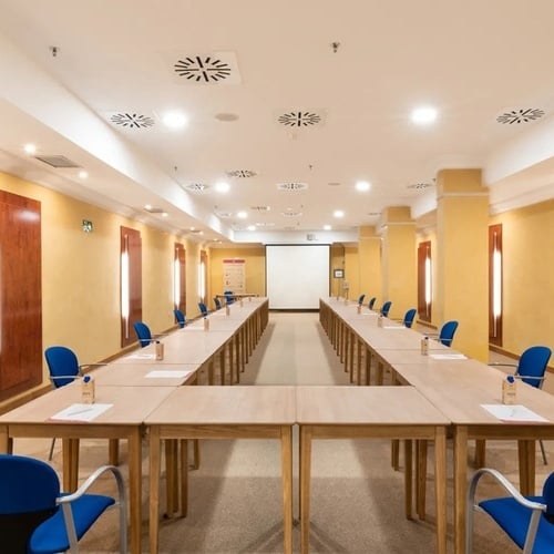 a conference room with a green exit sign on the wall