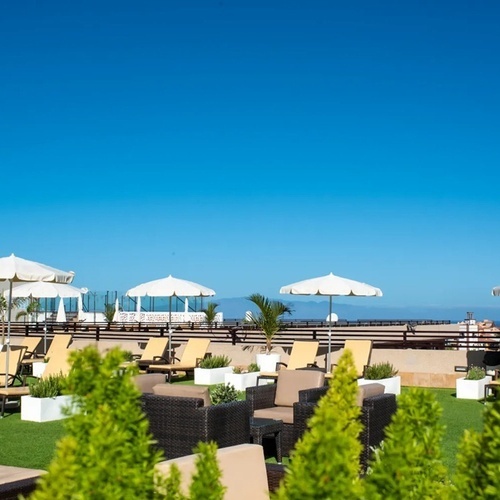 a patio area with chairs and umbrellas on a sunny day