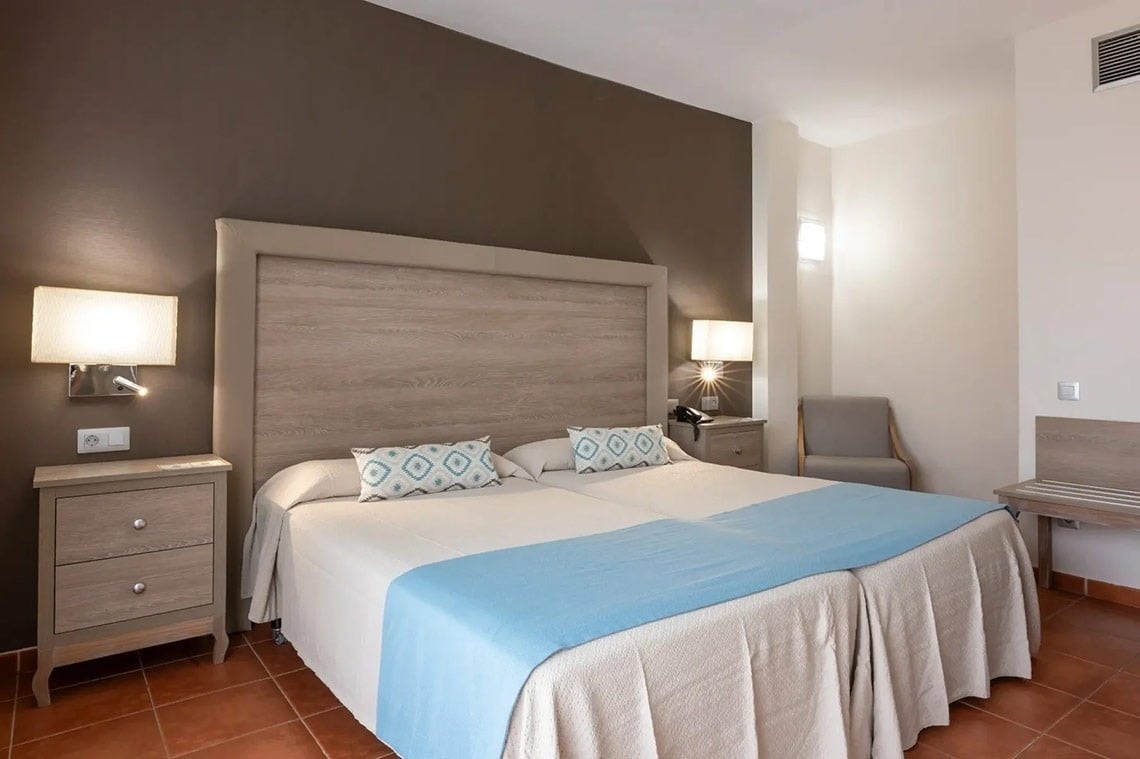 una habitación con dos camas y una mesita de noche