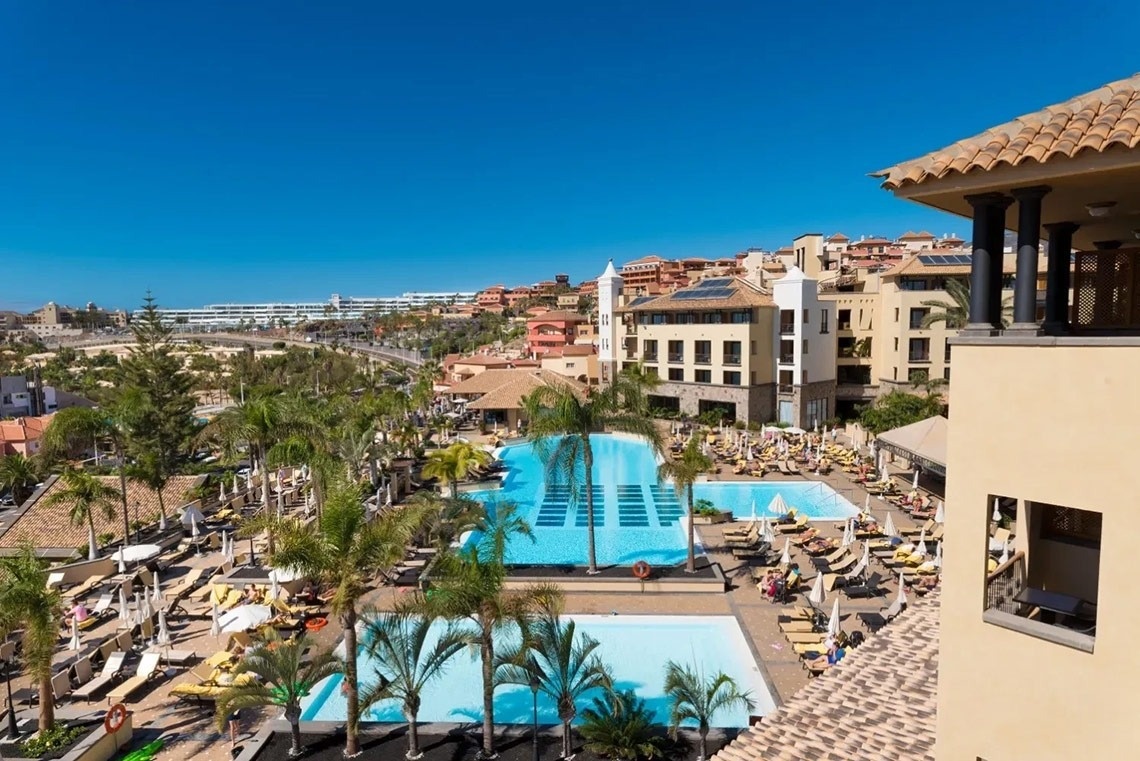 una gran piscina rodeada de palmeras en un resort