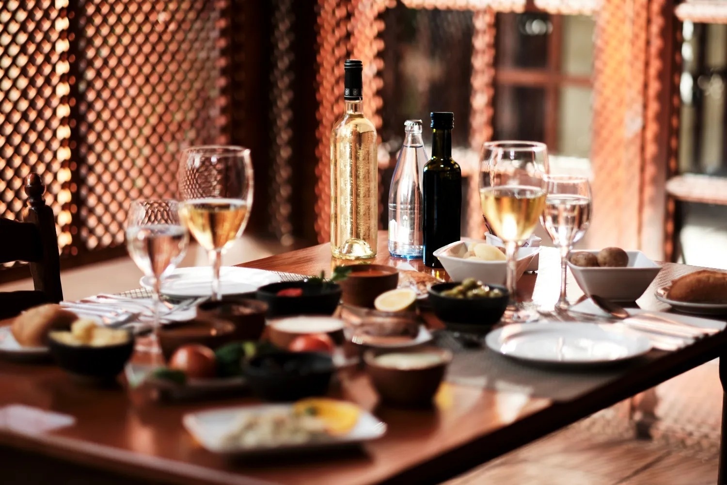 una mesa de comedor con platos y copas de vino