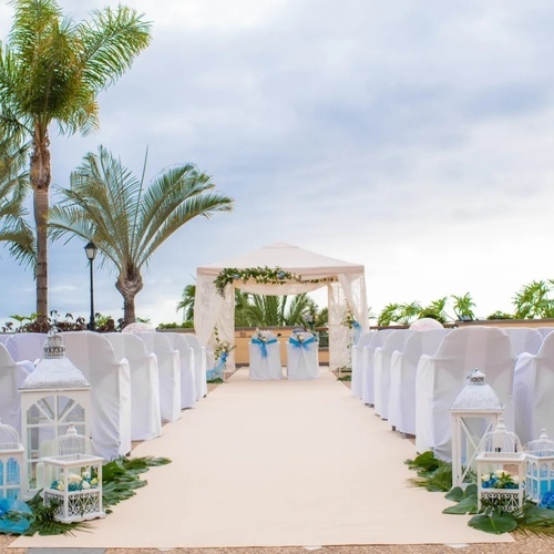 una ceremonia de boda al aire libre con sillas blancas y linternas