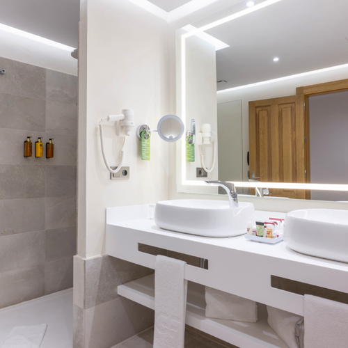 un baño de hotel con dos lavabos y una bañera