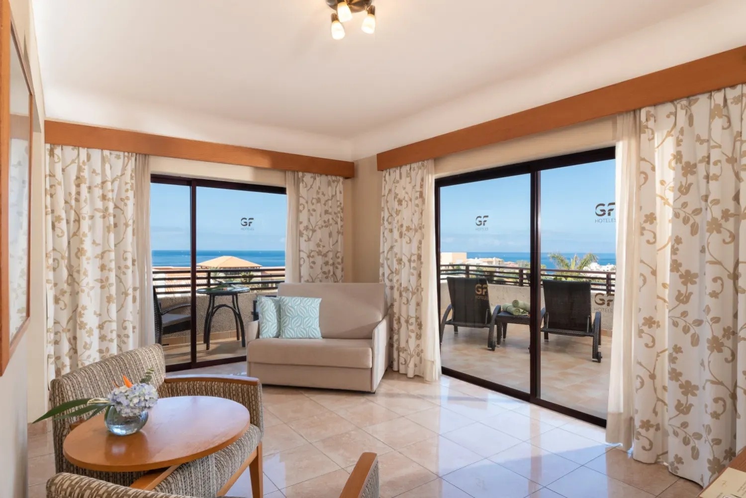 una habitación con un sofá y una mesa frente a una ventana con la palabra gf en el techo