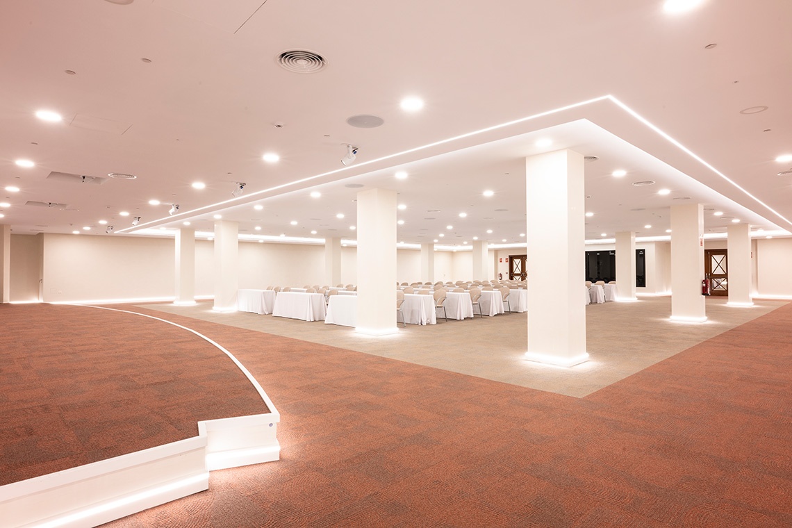 Corporate event space ready for conferences with blue tables and projection screen.