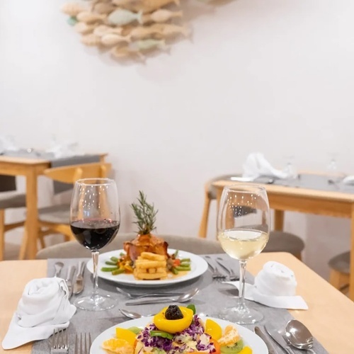 una mesa con platos de comida y copas de vino