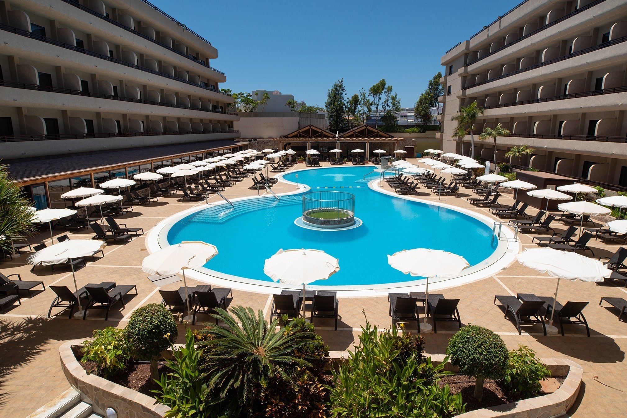 a large swimming pool surrounded by umbrellas and chairs