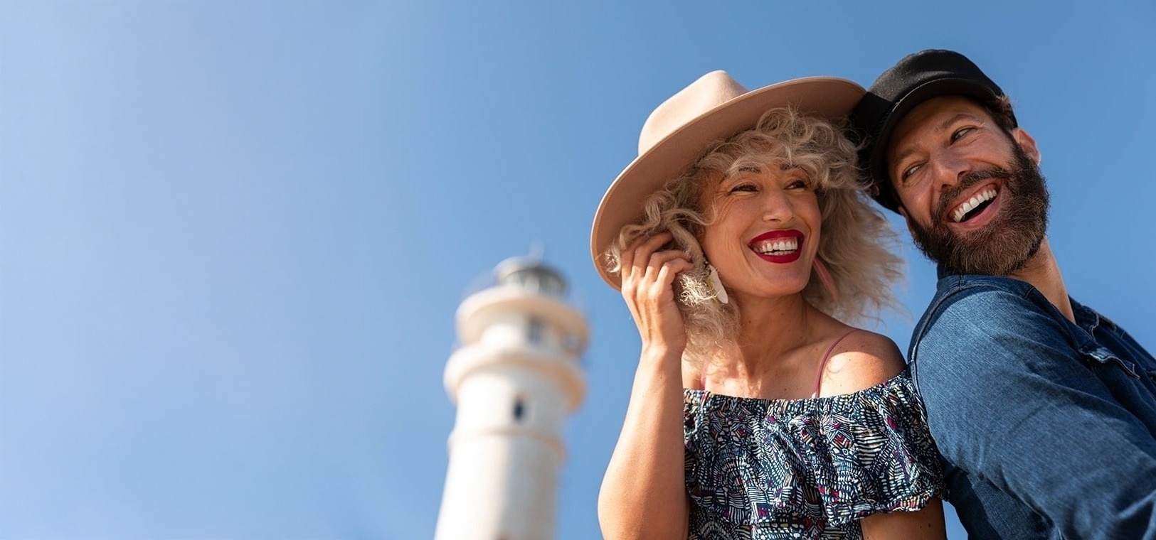 a woman wearing sunglasses and a white dress sits on the beach