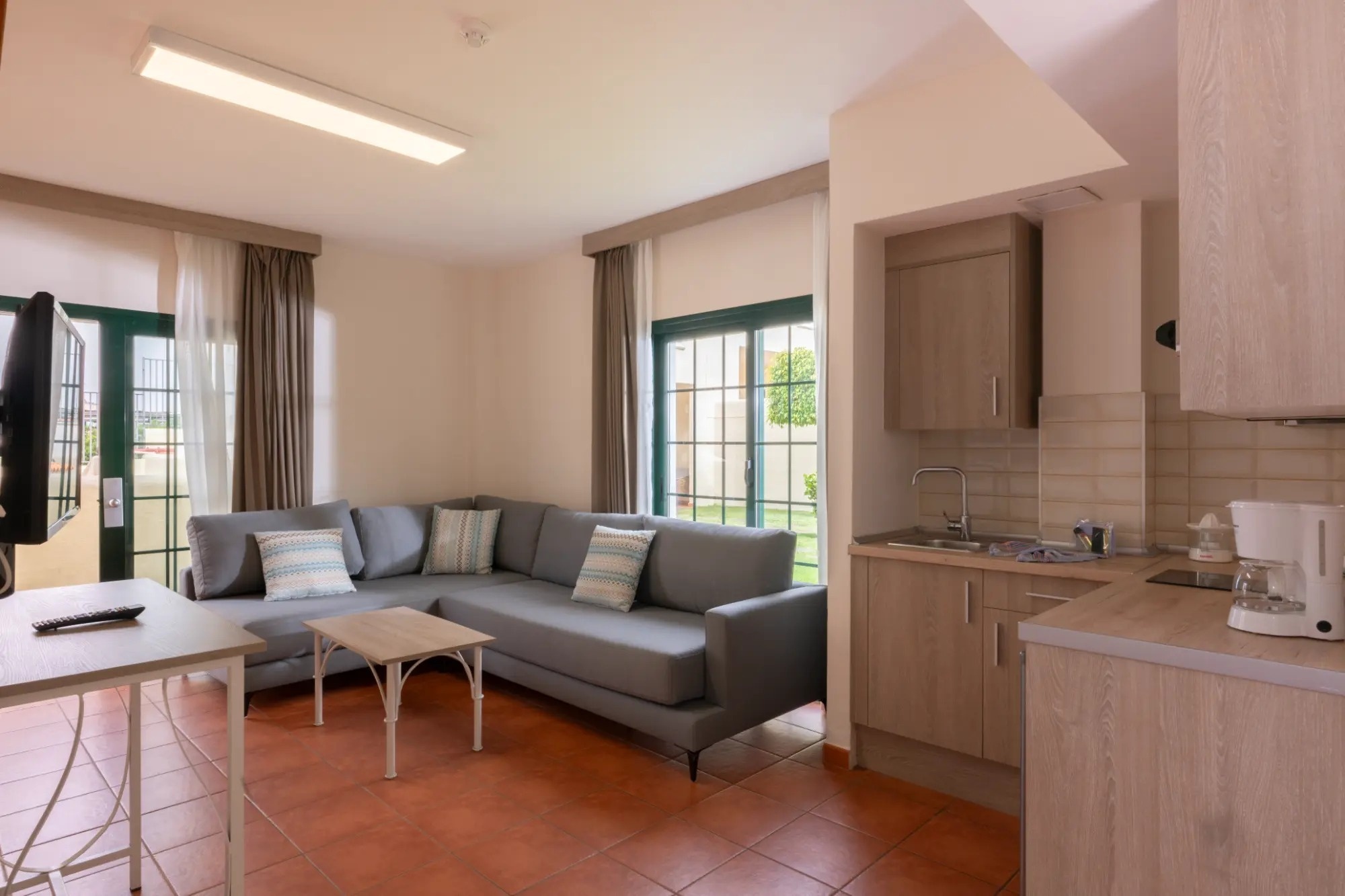 una cocina y una sala de estar con un sofá y una televisión