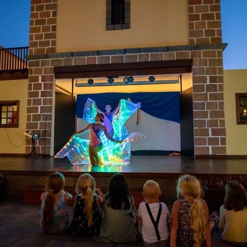a group of children are watching a performance on a stage