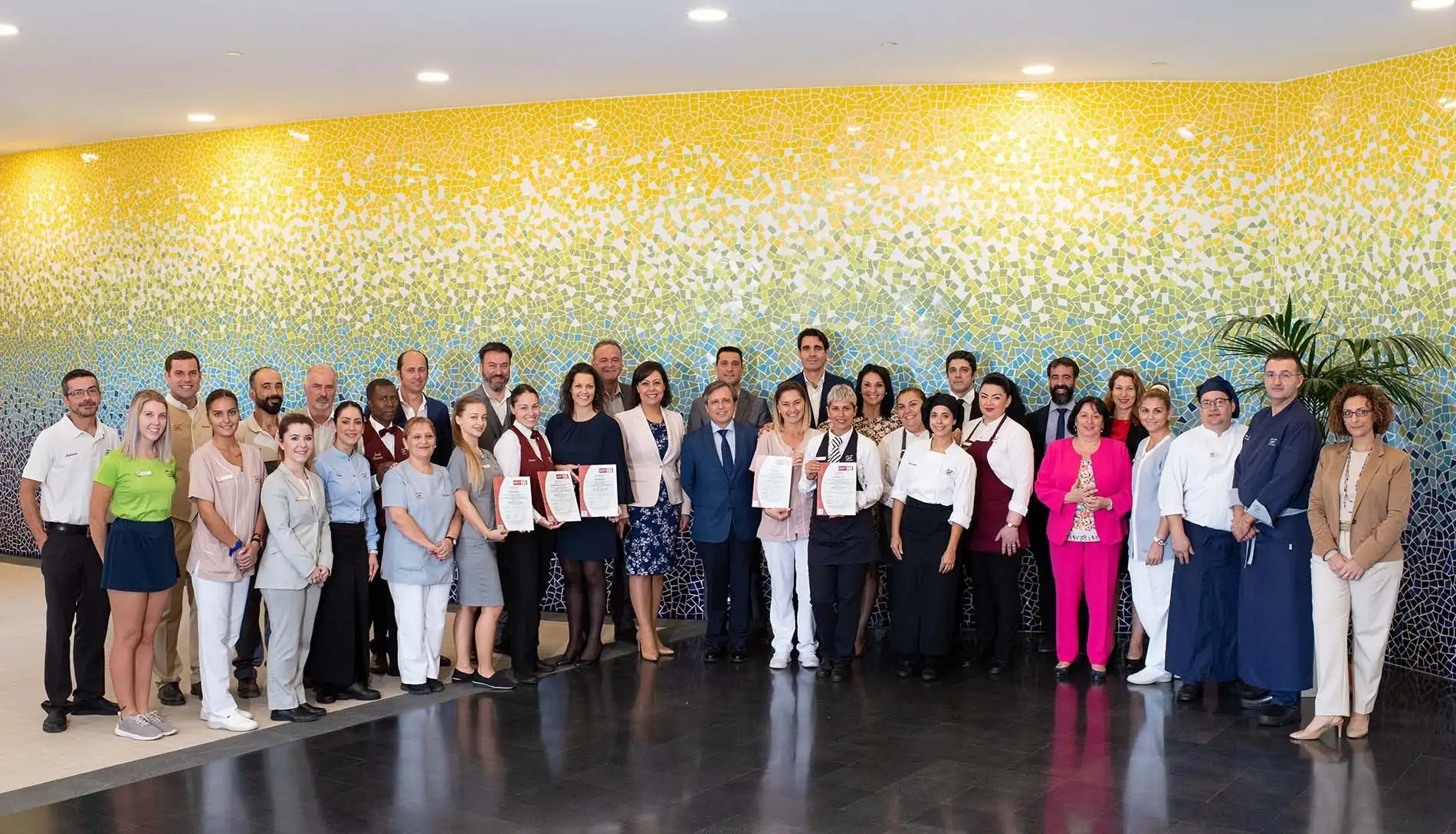 Equipo hotelero posa orgulloso con certificados. ¡Descubre nuestros servicios GF Hoteles!