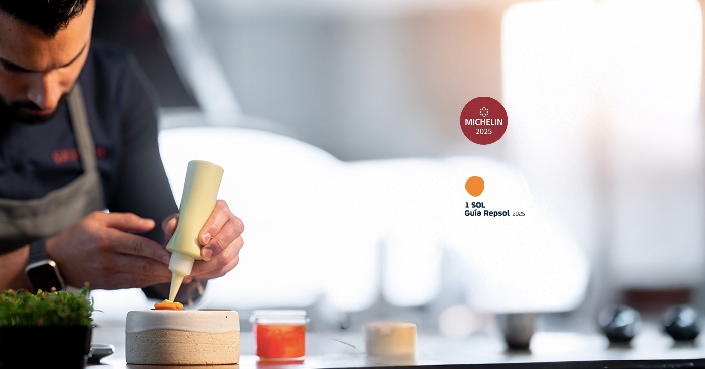 una mesa en un restaurante con un cartel rojo que dice michelin 2025