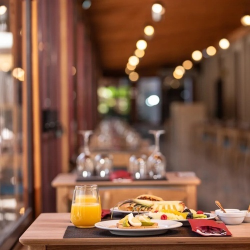 a table with a plate of food and a glass of orange juice