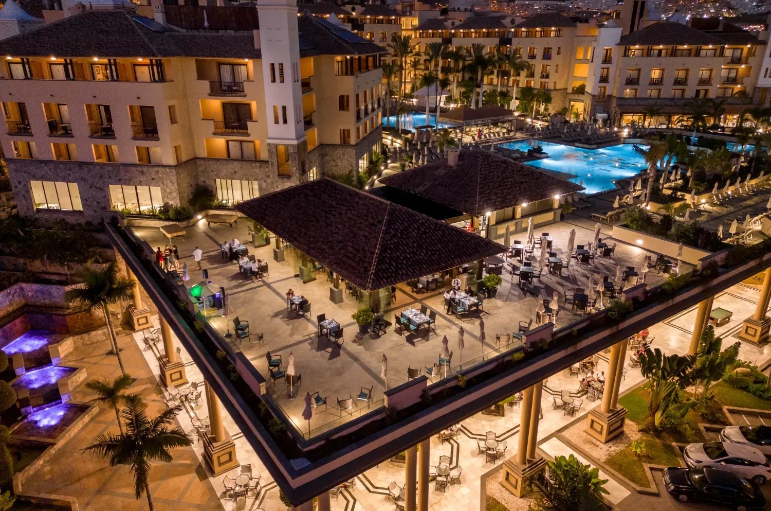 an aerial view of a hotel with tables and chairs on the roof