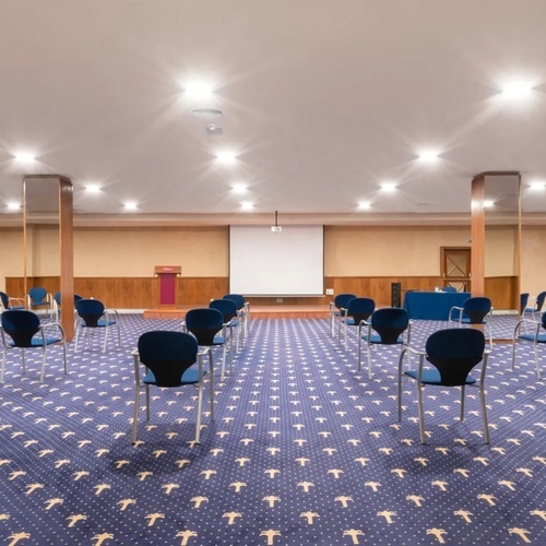 una sala de conferencias con sillas y un proyector