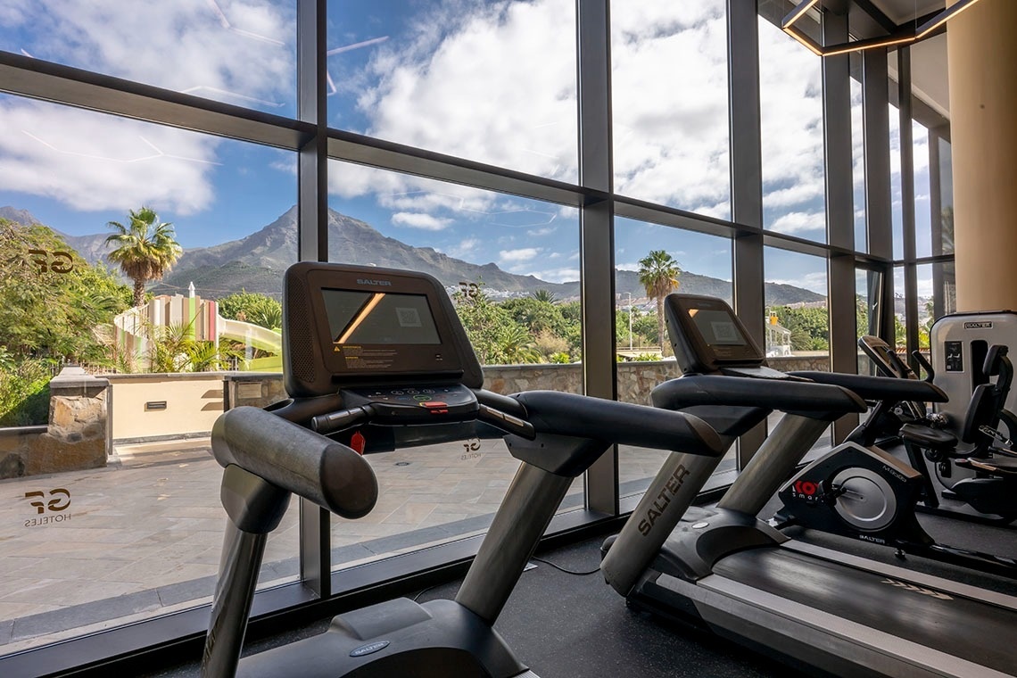 una mesa con copas de vino y un espejo con la palabra ajaj en la pared