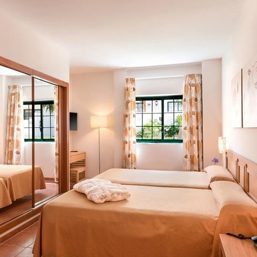 a hotel room with two beds and a window