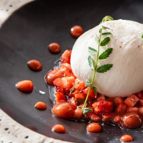 un primer plano de un plato de comida con un trozo de queso y fresas