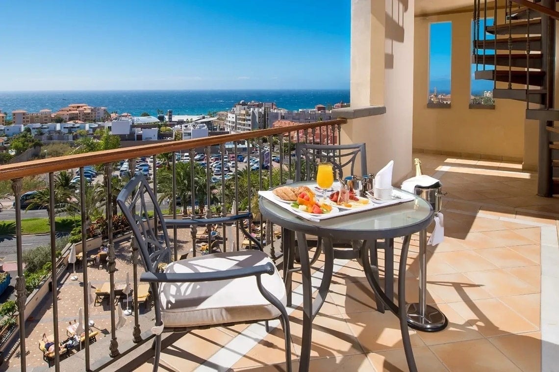 a balcony with a tray of food and a bottle of champagne