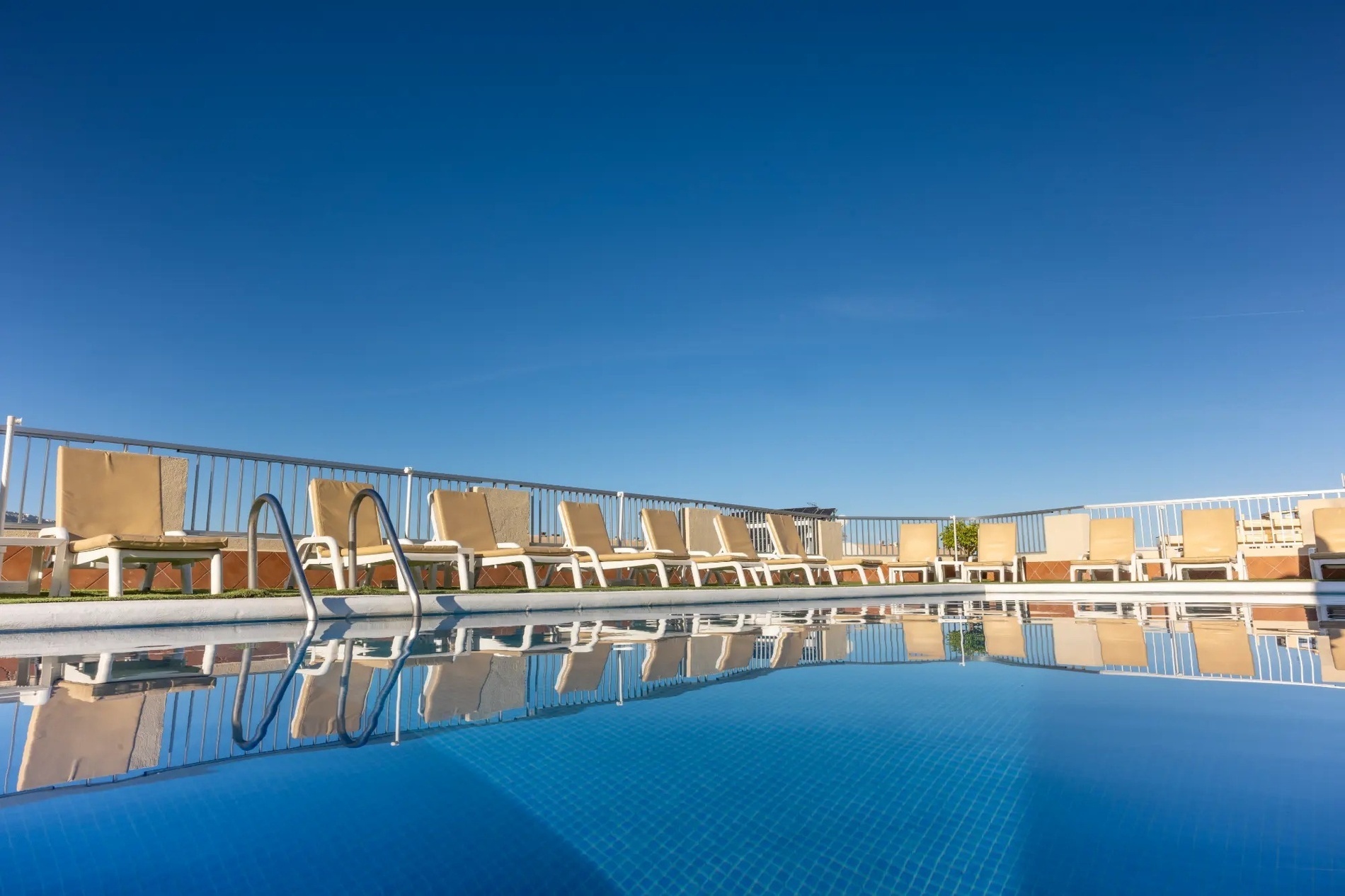 a swimming pool with umbrellas and chairs around it