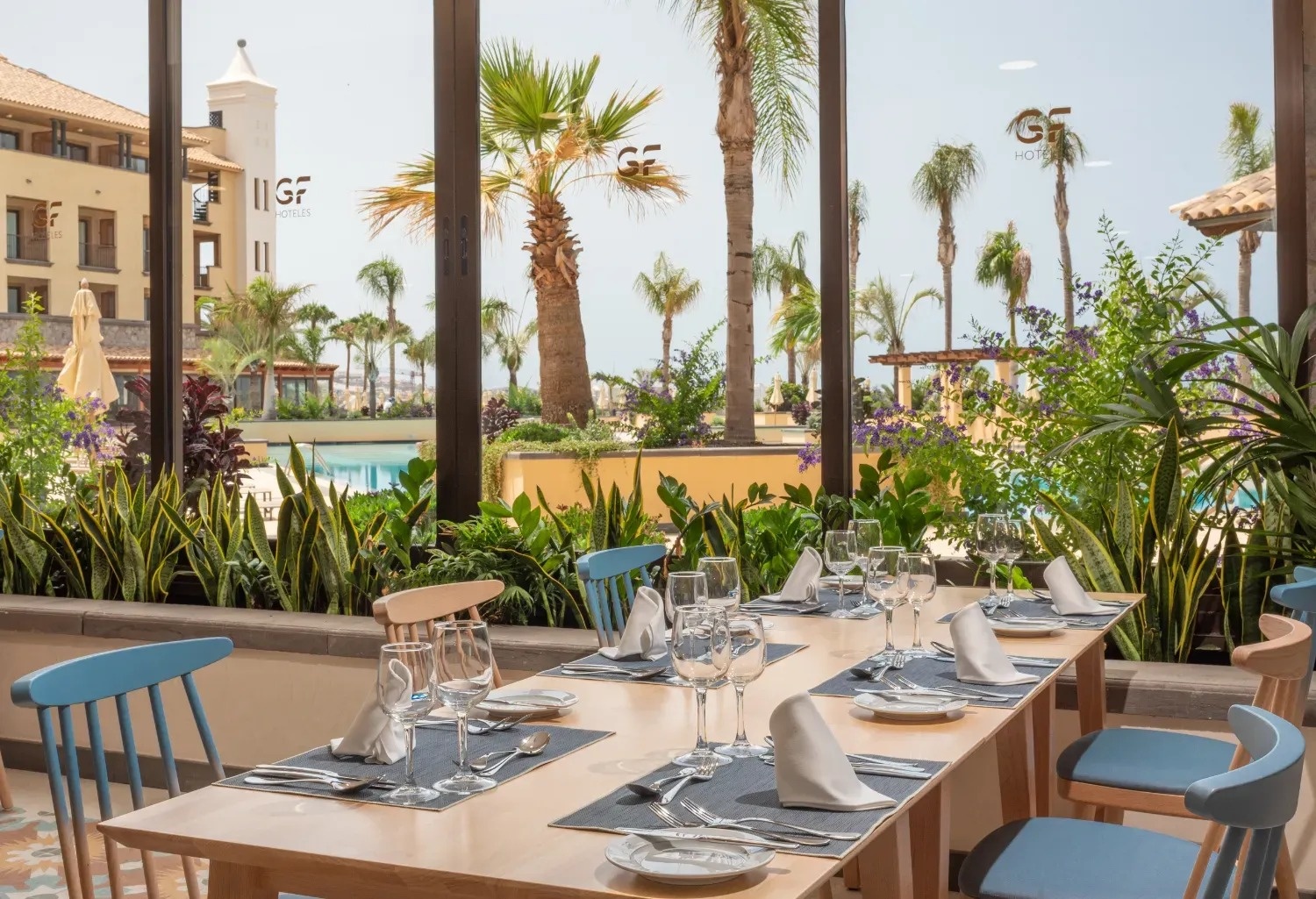 a restaurant with a view of a pool and palm trees