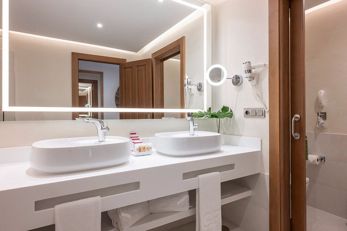 un baño con dos lavabos y un espejo